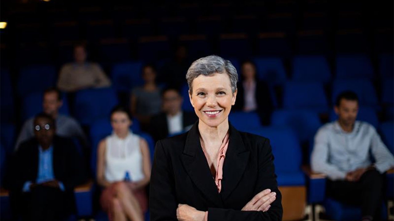 Experienced conference moderator hosting a UK corporate event